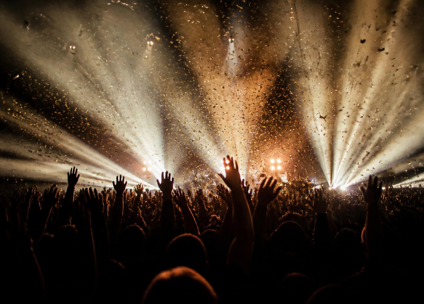 Concert crowd with confetti and spotlights